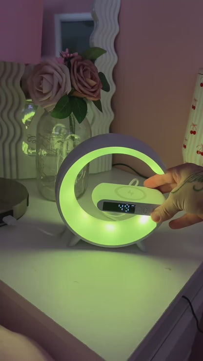 La lámpara con altavoz y cargador Bell + Howell es un dispositivo multifuncional 4 en 1 que combina un altavoz Bluetooth, una lámpara LED RGB, un cargador inalámbrico de 5 W para teléfono y un reloj despertador en un diseño elegante y compacto.